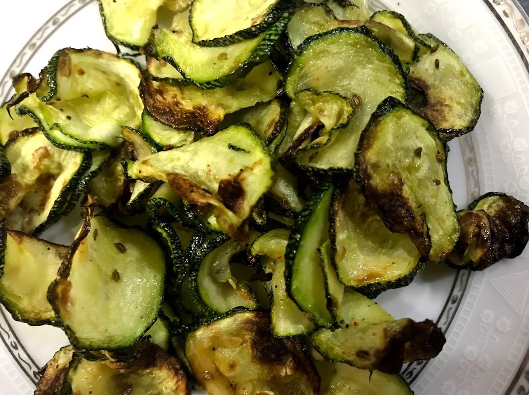 Thin air fried zucchini chips browned at the edges