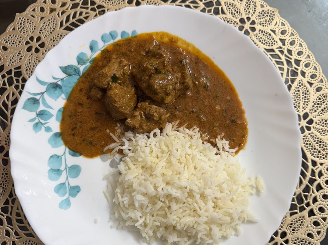 Chicken curry served beside a portion of plain boiled rice