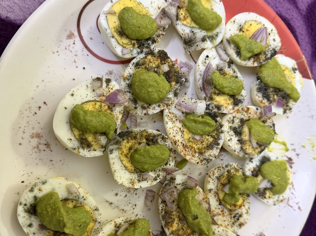 Halved devilled eggs topped with coriander mint chutney