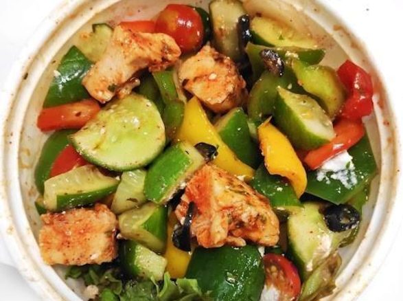 Greek chicken salad bowl with cucumber, peppers, olives and feta
