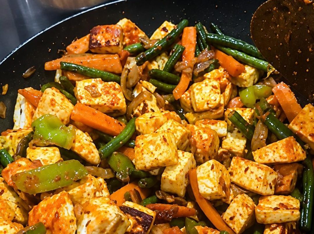 Low-carb paneer and vegetable jalfrezi with French beans, carrot and onion in a pan